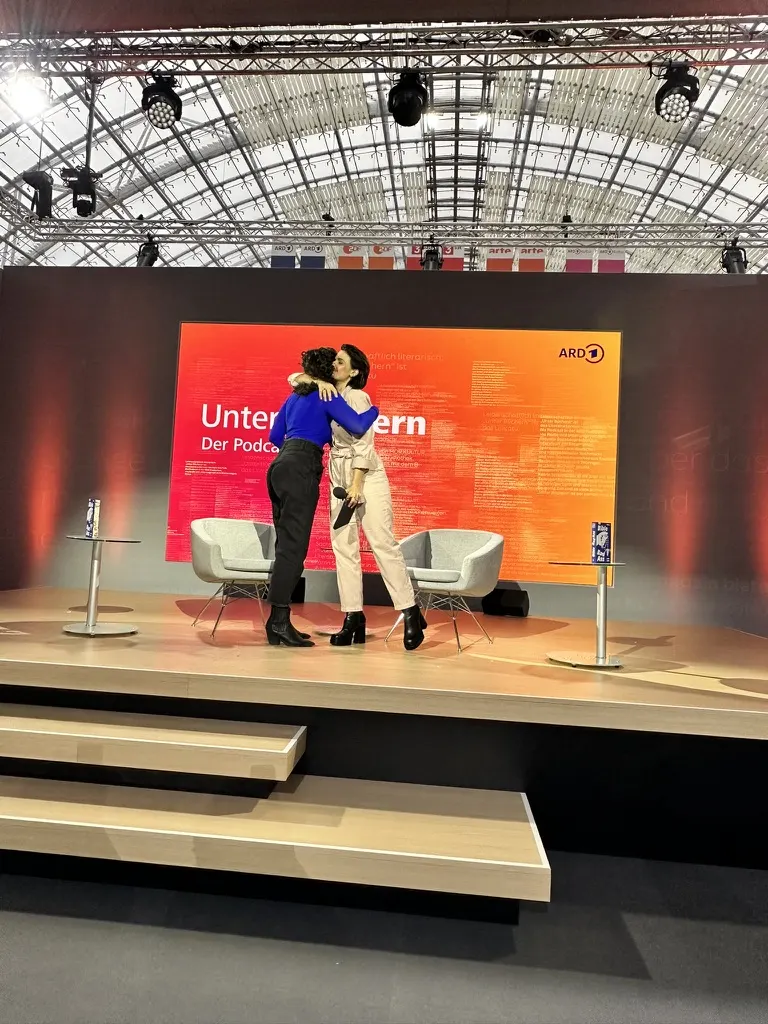 Yara Hoffmann moderiert einen ARD-Podcast auf der Bühne